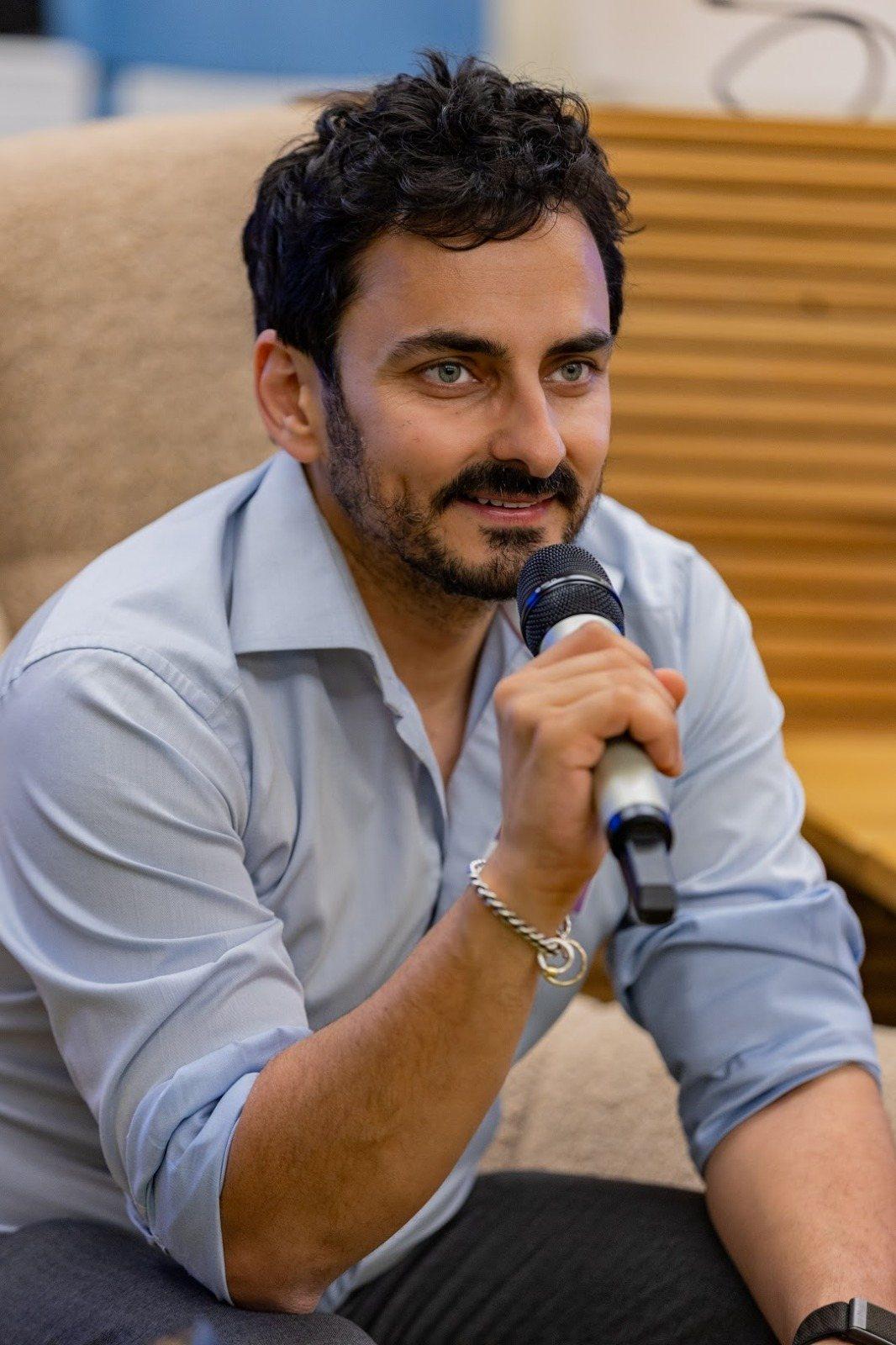 Adrien Naeem speaking into a microphone
